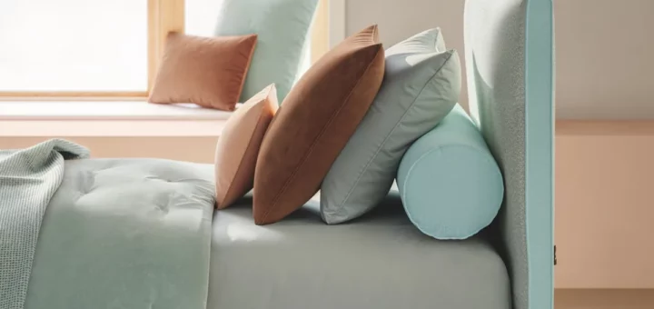 Letto Dread di Twils in una tonalità verde chiaro con cuscini rosa e pareti chiare