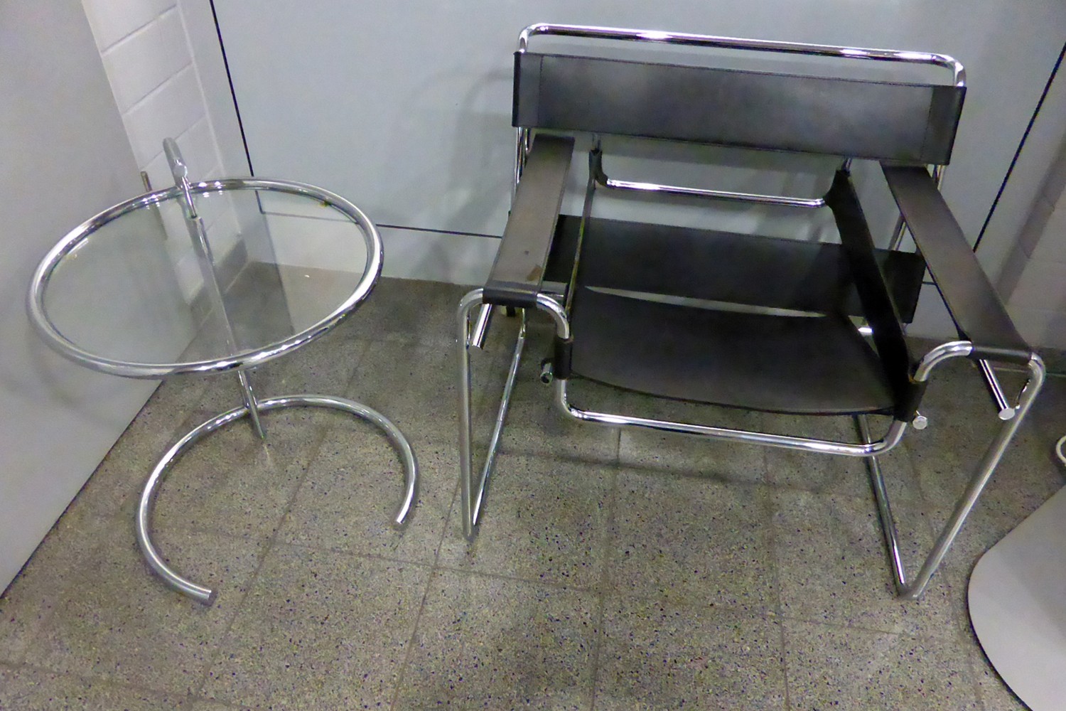 Poltrona Wassily di Marcel Breuer in tubolare d'acciaio e cuoio accanto al tavolino E-1027 di Eileen Gray