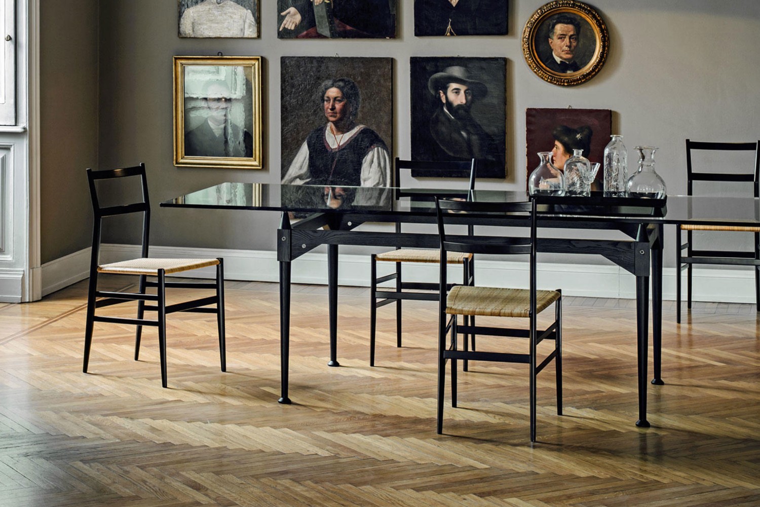 Sedie 699 Superleggera di Gio Ponti prodotte da Cassina attorno a un tavolo in un interno classico con parquet