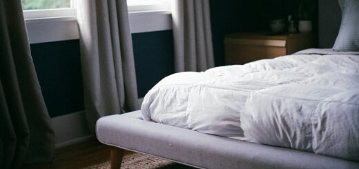 Letto con materasso e biancheria bianca vicino alla finestra